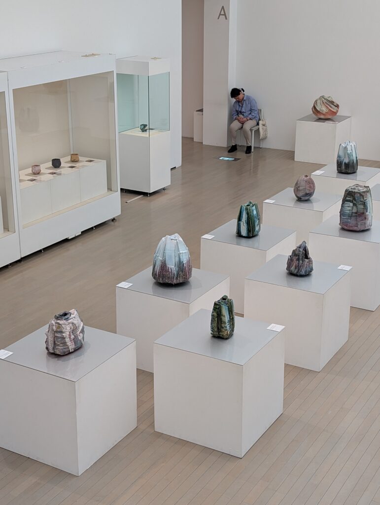 rough hewn shino vessels by Hayashi Shotaro on white pedestals and cases