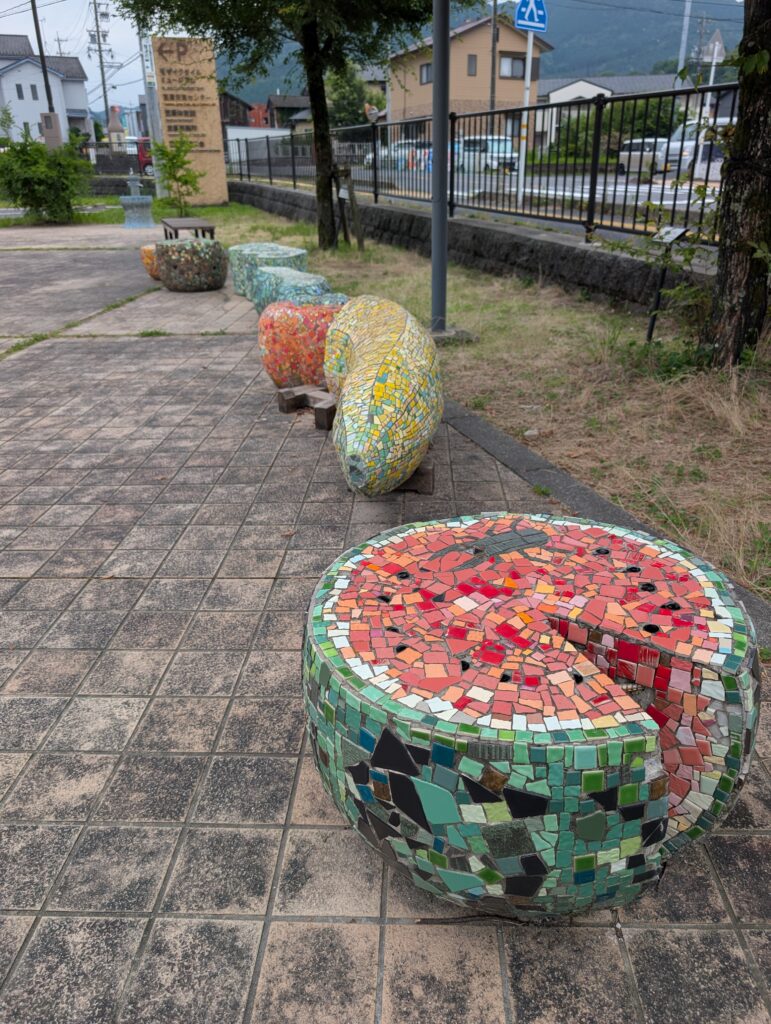 concrete bench seating made to look like fruit shapes covered in mosaic tile