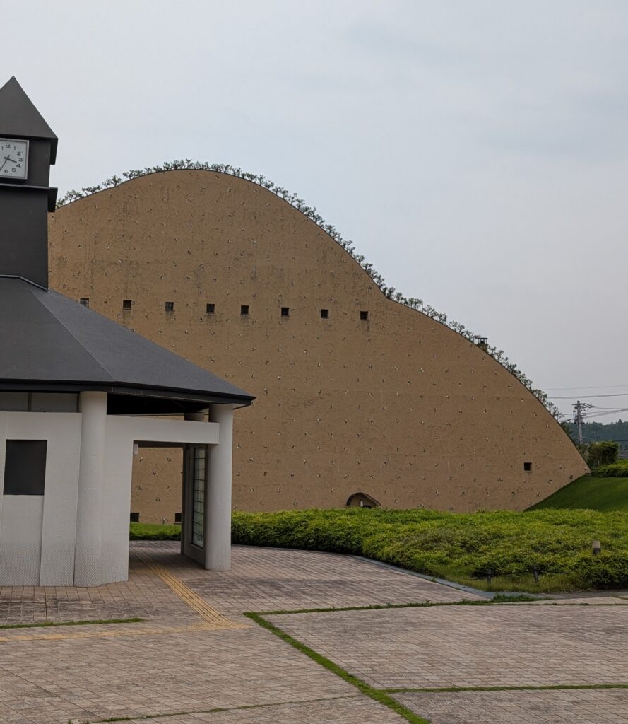 brown brick building with row of small windows on top